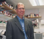 A portrait of a smiling Brian Roberts in his lab on the top floor of the Ingold Labs